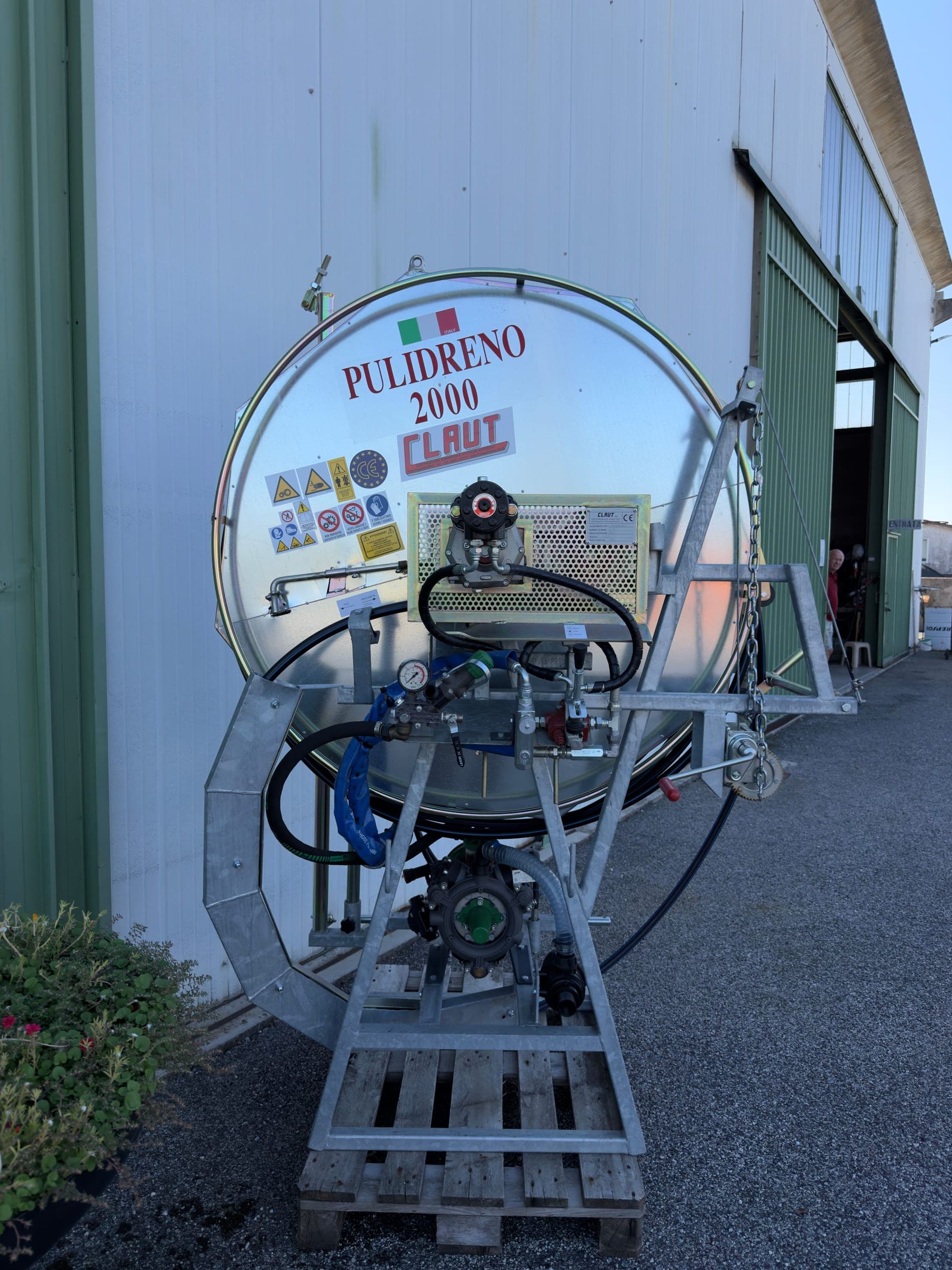 Pulidreno 2000 visto di fronte su un pallet: manometro e valvole di comando, la pompa a membrana in basso, il filtro in aspirazione, l’argano con la catena e dietro la bobina con la tubazione di lavoro